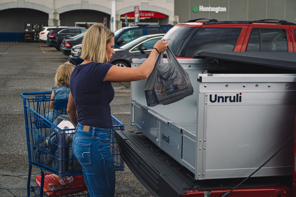 woman and baby loading groceries in back of pickup truck